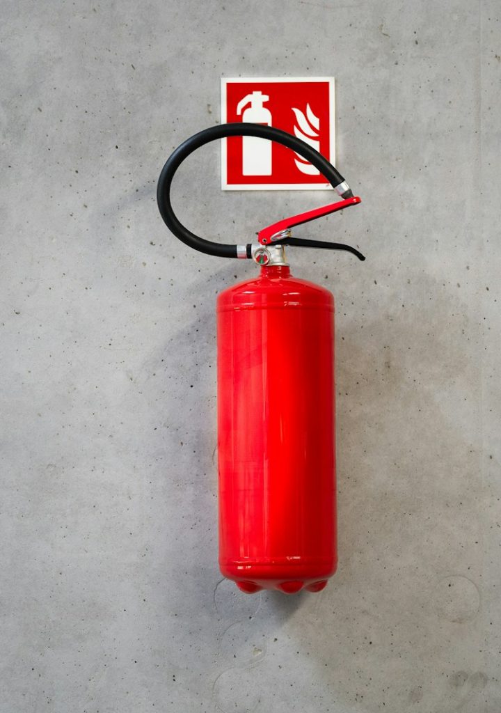 a red fire extinguisher hanging on a wall